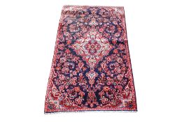A dark blue ground handmade rug.