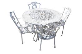 A white painted cast metal garden patio table and set of four chairs.