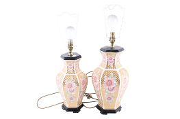 Two oriental style table lamps with shades. Matching designs, raised on hexagonal wooden stands.