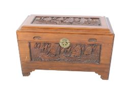 Chinese carved camphor wood trunk. Carved panels to each side depicting scenes of boats under sail.