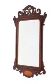 A Georgian fretwork mahogany framed wall mirror. Having carved phoenix and inlaid shell decoration.