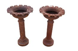 A pair of modern cast iron pedestal garden planters. Having fluted columns on round bases.