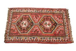 Persian style wool rug on a red ground.