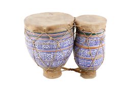 Set of two hand drums. Having blue and white pottery bodies with leathers heads.