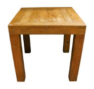 A contemporary square top oak table. Raised on square supports.
