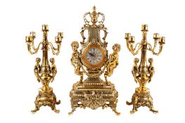 A gilt and ornate decorated reproduction 'chateau' style mantel clock and a pair of candleabras.