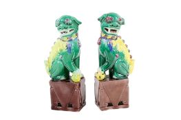 Pair of Chinese ceramic Dogs of Foo (af). Polychrome glazes raised on a plinth.