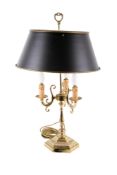 A brass bouillotte table lamp with metal shade. Raised on a hexagonal base.