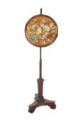 A Victorian rosewood pole screen on tripod base. The round panel with an embroidery of flowers.
