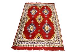A Persian style wool rug on a red ground.