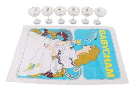 A collection of six Babycham glasses and a branded tea towel.