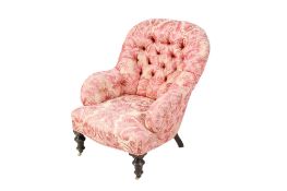 A Victorian pink floral upholstered button back lounge armchair. Raised on turned tapering supports.