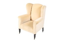 Edwardian wing back armchair. Raised on square tapering supports with brass casters.