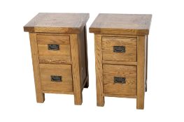 A pair of contemporary oak bedside set of drawers. With swing metal handles.