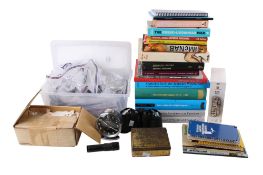 A quantity of assorted vintage binocular spare parts and a collection of related books.