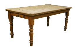 A rectangular pine kitchen table. Having a drawer to one end raised on turned baluster supports.