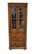 A 20th century stained oak and glazed corner cabinet.