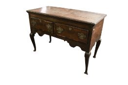 An 18th century oak dresser base. Fitted with two drawers, raised on cabriole supports.