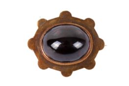 A 15ct gold and garnet mourning brooch. Set with a large cabochon cut garnet of circa 1.5cm x 1.