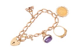 A 15ct gold charm bracelet set with a half sovereign, fobs and a ring.