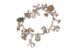 A white metal charm bracelet. Charms including animals, a yacht, cow bell, etc, gross weight 33g.