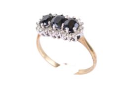 A 9ct yellow gold dress ring. Set with three dark sapphires and diamonds, size Q, gross weight 2.