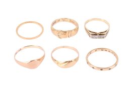 Six gold and yellow metal rings.