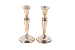 A pair of Cartier silver candlesticks. Weighted, of classical form on a spread foot.