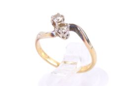 An 18ct gold two stone diamond cross-over ring. The stones circa 2.