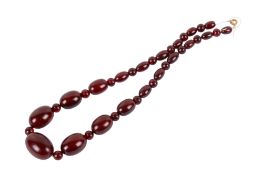 A vintage cherry amber bakelite graduated necklace. The largest bead 2.3cm, L45cm, weight 30.