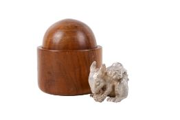 A silver model of a squirrel in a turned wood box.