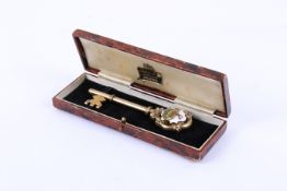 A gold plated silver key. With enamelled motif of a stag in a pen, hallmarks for Birmingham 1934.