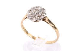 A yellow metal and diamond cluster ring.
