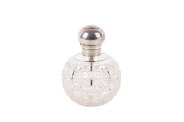 A large silver topped cut glass atomizer.