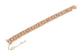 A yellow metal gate-link bracelet.