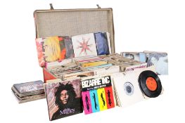 A collection of assorted 7 inch 45 rpm vinyl single records. In an orange suitcase.