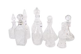 Nine assorted crystal glass decanters.