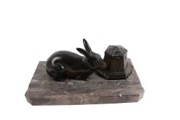 An Art Deco style 'rabbit' desk inkwell pen stand. Raised on a grey marble base.
