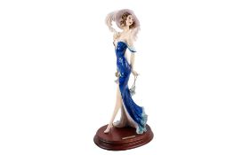 A resin Sautini figure modelled as a lady raised on an oval wooden base.