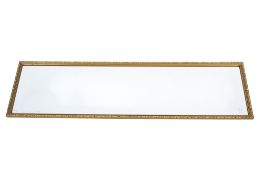 A modern gilt framed long mirror. The frame with floral details in relief, 119.5cm x 33.5cm.