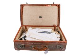 A vintage brown leather suitcase and a quantity of mostly gents clothing.