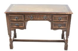 A mid-century carved oak desk with green inset leather top.