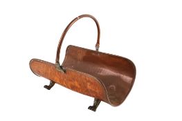A hand beaten copper fire side log basket with brass paw feet.