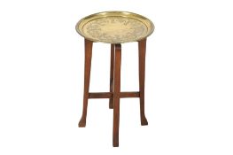 A brass tray topped table raised on an oak frame. The tray with bird and leaf decoration.