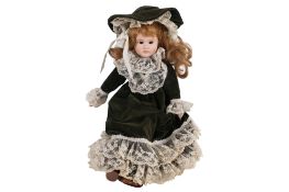 A Victorian style doll. With painted porcelain head, dressed in green and lace. H46cm.