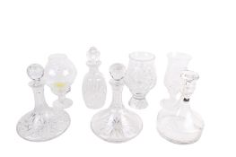 A group of crystal decanters and glass hurricane lamps.
