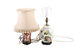 Two early 20th century ceramic table lamps raised on circular wooden bases.