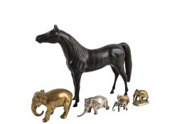 Six cast metal animal figures. Including brass elephants, a brass horse glazed black and more, Max.