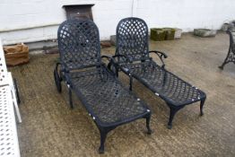 A pair of metal outdoor chaise lounge sunbed chairs. With adjustable backrests and wheels. Painted