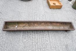 A heavy cast iron trough. With drainage holes. L178cm W27cm H15cm. All items in this auction are